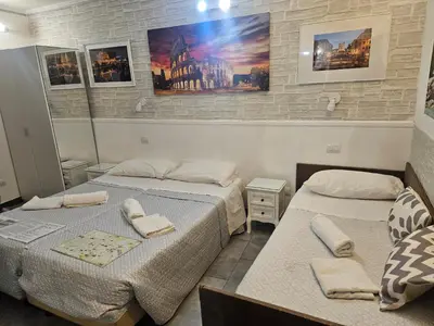 two beds in a room with paintings on the wall at A&F Colosseo in Rome