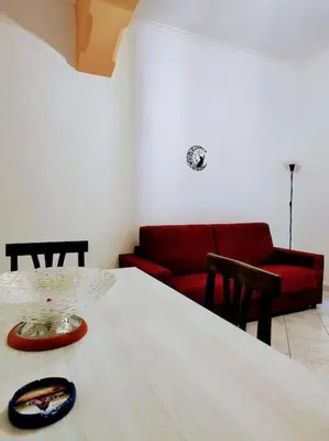 a living room with a table and a red couch at Notti di San Lorenzo in Rome