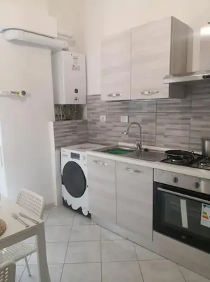 a kitchen with a sink and a washing machine at Notti di San Lorenzo in Rome