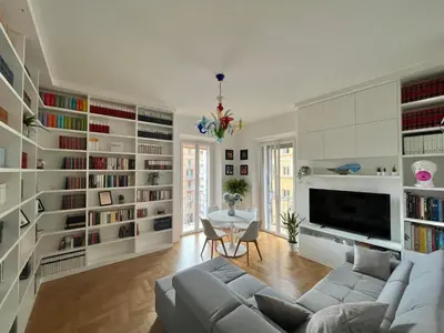 a living room with a couch and book shelves at Sunrise House - San Giovanni in Rome