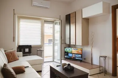 a living room with a white couch and a tv at Two Bedroom Appartment - 3 min Metro Conca D'Oro by ORPI RENT in Rome