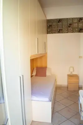 a small bedroom with a bed and a cabinet at Two Bedroom Appartment - 3 min Metro Conca D'Oro by ORPI RENT in Rome