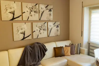 a living room with a white couch and paintings on the wall at Two Bedroom Appartment - 3 min Metro Conca D'Oro by ORPI RENT in Rome