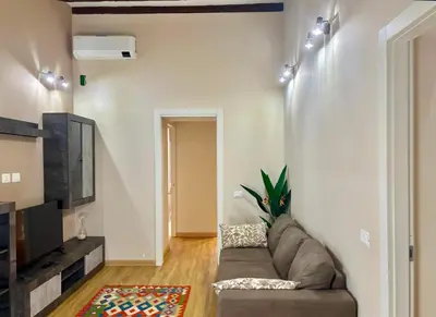 a living room with a couch and a tv at DaliTourism - Nazionale Charme in Rome