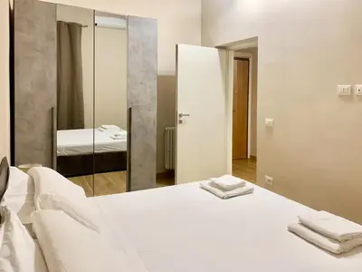 a bedroom with a white bed and a mirror at DaliTourism - Nazionale Charme in Rome