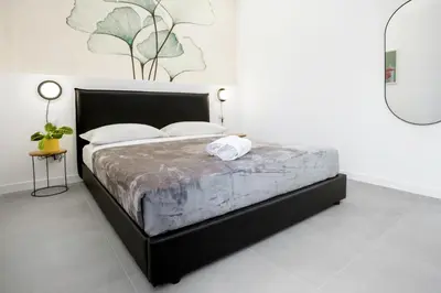 a bedroom with a large bed in a white room at Re di Roma Luxury Suite in Rome