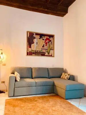 a living room with a blue couch and a painting at Appartamento storico borgo Pio in Rome