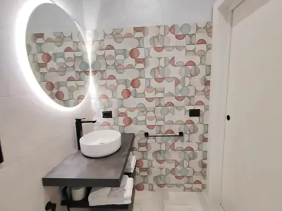 a bathroom with a sink and a stone wall at Crystal Domus in Rome