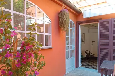 an orange house with flowers in front of a door at Deco Garden Apartment Trastevere in Rome