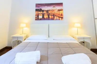 a bedroom with a large bed with two lamps at Vespasiano 49 in Rome