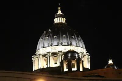 a building with a domed building at night at Maison Cavalleggeri in Rome