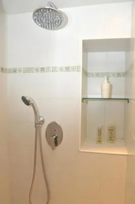 a shower with a shower head in a bathroom at MIGDAL Luxury Suites Roma Porta Portese in Rome
