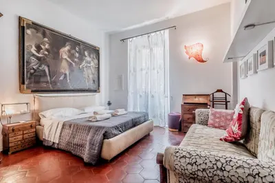 a bedroom with a bed and a couch and a painting at 