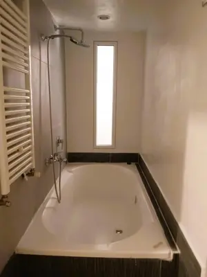a white bath tub in a bathroom with a window at San Cosimato cozy flat in Rome