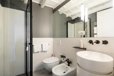 a bathroom with a sink and a toilet and a mirror at Elegance and Charm in Splendid Via Giulia in Rome