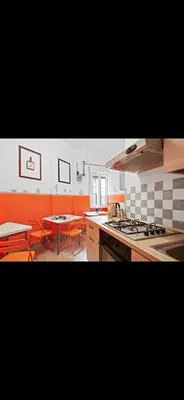 a kitchen with a stove and a table with chairs at Casa di Flavio a San Pietro in Rome