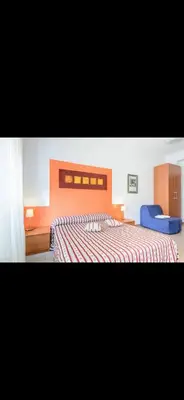 a bedroom with a large bed and a blue chair at Casa di Flavio a San Pietro in Rome