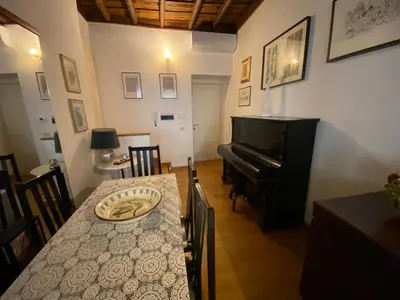 a dining room with a table and a piano at Leonina Luxury Euroform in Rome
