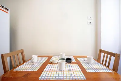 a wooden table with three plates and cups on it at King Size Apartment WiFi AIR CONDITIONING TV50 10MIN COLOSSEO-TRASTEVERE in Rome