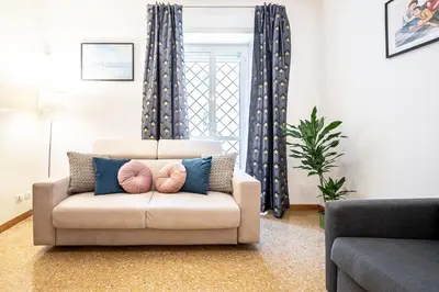 a living room with a couch with pillows at King Size Apartment WiFi AIR CONDITIONING TV50 10MIN COLOSSEO-TRASTEVERE in Rome
