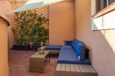 a patio with a blue couch and a table at Daplace - Romina Apartment in Rome