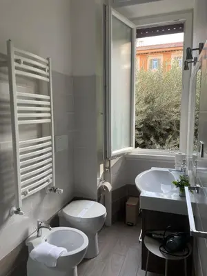 a bathroom with a toilet and a sink and a window at Sweet Anna in Rome