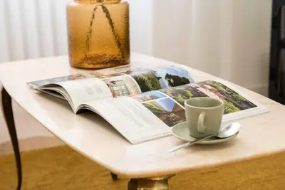 a book on a table with a cup and a candle at Monte Sacro apartment for 6 guests Metro B in Rome