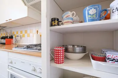 a kitchen with cups and dishes on a shelf at ht mama bilo vatican area in Rome