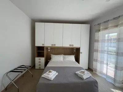 a bedroom with a bed with white cabinets and a window at Chic&Elegant Retreat in Rome in Rome
