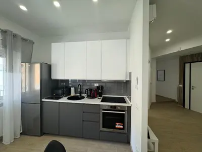 a kitchen with stainless steel appliances and white cabinets at Chic&Elegant Retreat in Rome in Rome
