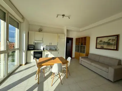 a kitchen and living room with a table and a couch at Bright apt near Porta Maggiore in Rome