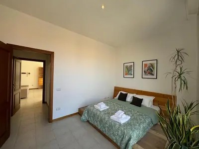 a bedroom with a bed and a plant in it at Bright apt near Porta Maggiore in Rome