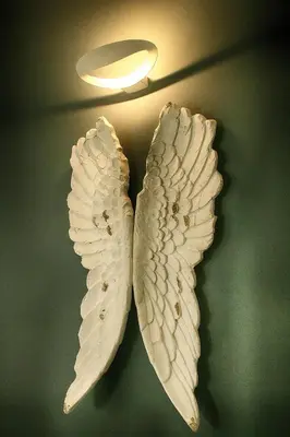 two white wings hanging from a light fixture at Vatican Angels Casa Vacanze in Rome