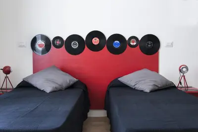 two beds in a room with records on the wall at Grammy Suite in Rome