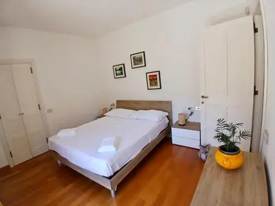 a bedroom with a white bed and a potted plant at Luce, Silenzio ed Eleganza nel Cuore di Roma - 2 camere da letto in Rome