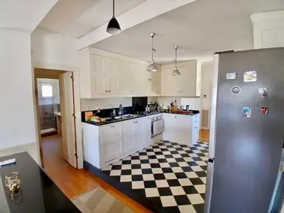 a kitchen with white cabinets and a checkered floor at Luce, Silenzio ed Eleganza nel Cuore di Roma - 2 camere da letto in Rome