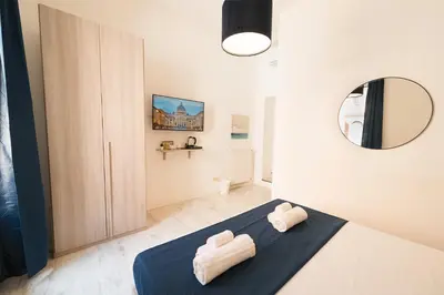 a bedroom with a bed and a mirror in a room at Barletta Vatican Rooms in Rome