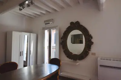 a dining room with a table and a mirror on the wall at Pantheon Suite in Rome