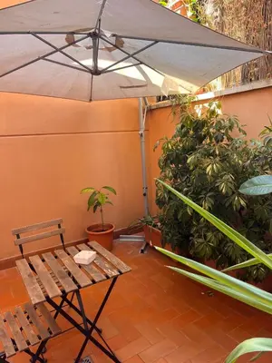 a patio with a bench and an umbrella at Cortile San Tommaso in Rome