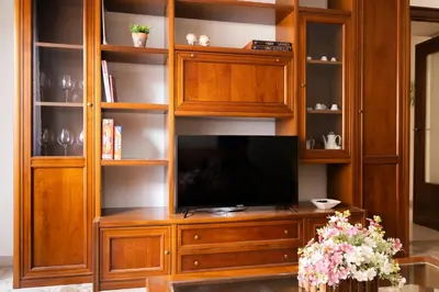 a wooden entertainment center with a flat screen tv at Appartamento Scena Vaticana in Rome