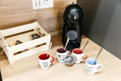 a coffee maker and four cups of coffee on a counter at Maison Chic Cornelia - San Pietro in Rome
