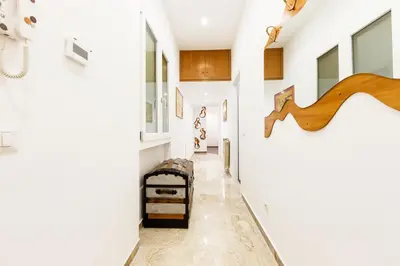 a hallway with white walls and a staircase with a wooden stair case at Maison Chic Cornelia - San Pietro in Rome