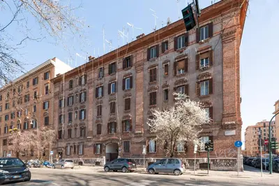 a large brick building with cars parked in front of it at Loving Testaccio in Rome