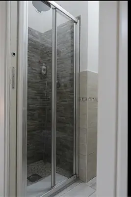 a shower with a glass door in a bathroom at Le Stanze di Elisa in Rome