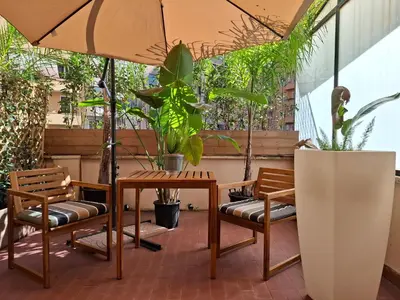 a patio with a table and chairs and plants at Appian Private Suites in Rome