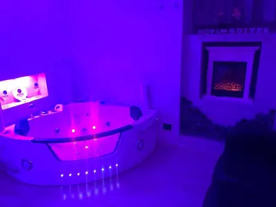 a purple bathroom with a tub with a fireplace at Moya Suites 2 - SPA in Camera in Rome