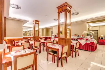 a dining room with tables and chairs in a restaurant at Augusta Lucilla Palace in Rome