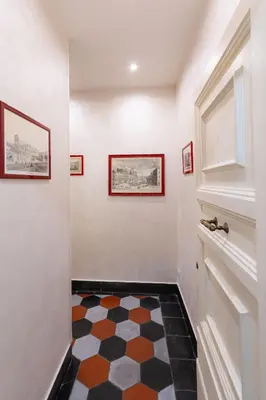 a hallway with a checkered floor and two framed pictures at Sweet Navona Duplex Apartment in Rome