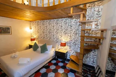 a room with two beds and a spiral staircase at Sweet Navona Duplex Apartment in Rome