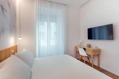 a bedroom with a bed and a desk and a tv at Caesar Boutique Apartment in Rome